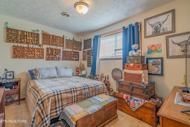 bedroom featuring visible vents, carpet floors, and a textured ceiling