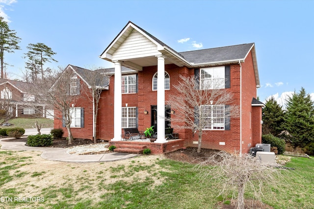 neoclassical home featuring a front lawn, brick siding, and crawl space