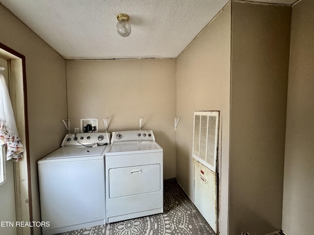 washroom with a textured ceiling, laundry area, and separate washer and dryer