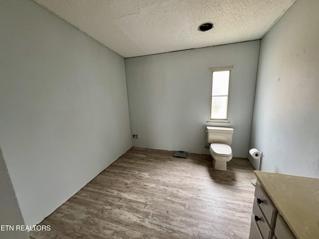 bathroom featuring vanity, wood finished floors, and toilet