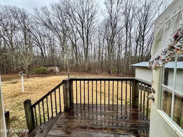 wooden deck featuring a lawn