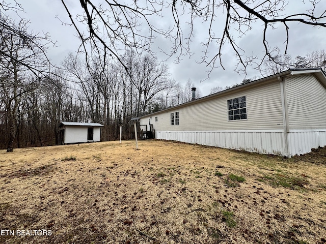 view of side of property with an outbuilding and a shed