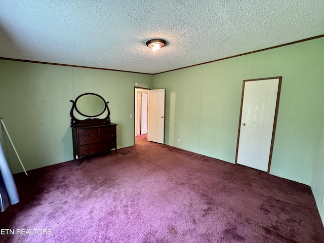 unfurnished bedroom with ornamental molding, carpet flooring, and a textured ceiling