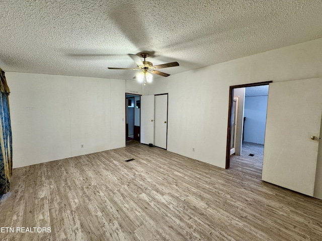 unfurnished bedroom with wood finished floors, a textured ceiling, and ceiling fan