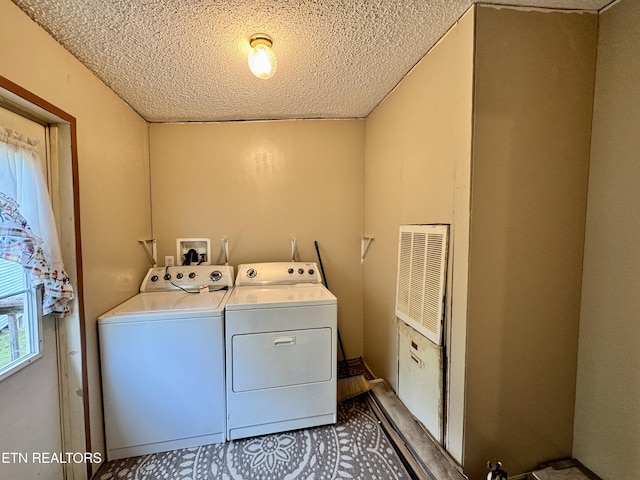 laundry area with a textured ceiling, visible vents, separate washer and dryer, and laundry area