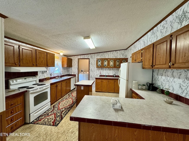 kitchen featuring a sink, wallpapered walls, under cabinet range hood, white appliances, and ornamental molding