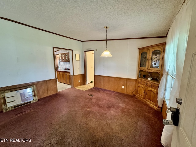 unfurnished room with wainscoting, carpet floors, and ornamental molding