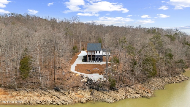 birds eye view of property featuring a water view and a view of trees