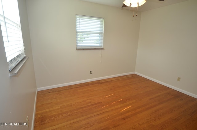 unfurnished room featuring a ceiling fan, baseboards, and wood finished floors