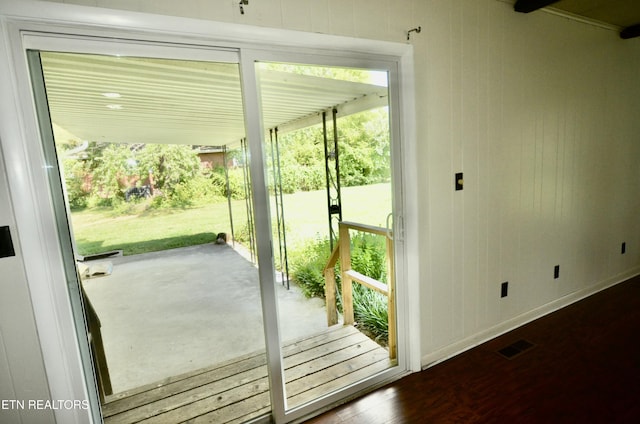 doorway to outside featuring wood finished floors, visible vents, and baseboards