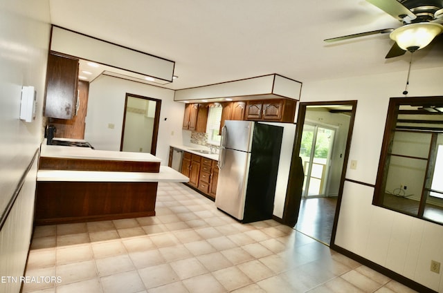 kitchen with appliances with stainless steel finishes, light countertops, a sink, and ceiling fan