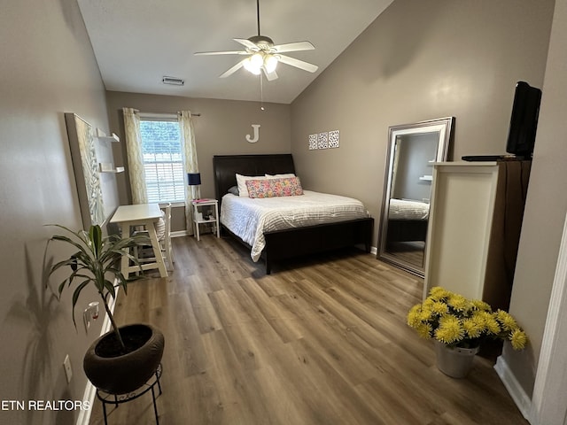 bedroom with visible vents, vaulted ceiling, baseboards, and wood finished floors