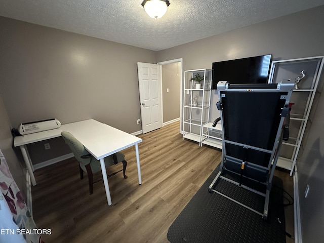 office space featuring a textured ceiling, baseboards, and wood finished floors