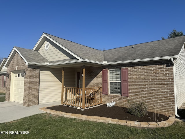 view of front of house featuring brick siding, covered porch, and an attached garage