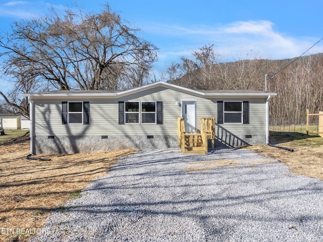 manufactured / mobile home featuring crawl space and gravel driveway