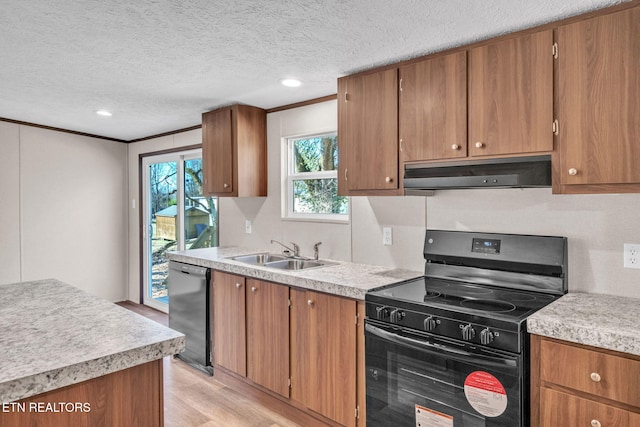 kitchen featuring brown cabinetry, under cabinet range hood, light countertops, black appliances, and a sink