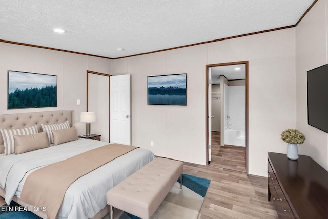 bedroom with a textured ceiling, ornamental molding, and light wood-style flooring