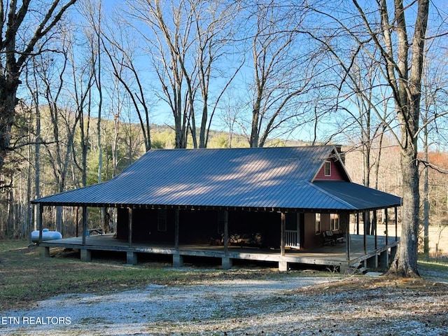 farmhouse inspired home featuring a porch and metal roof