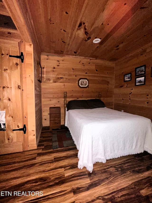 bedroom featuring wooden walls, wooden ceiling, and wood finished floors