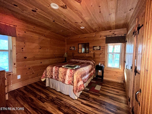 bedroom with dark wood finished floors, wood walls, and wooden ceiling