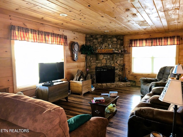 living room with a stone fireplace, wood finished floors, wood ceiling, and wood walls