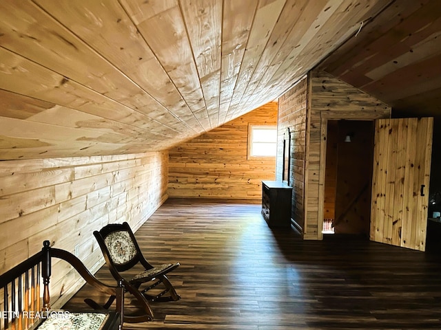 additional living space featuring lofted ceiling, dark wood-style floors, wooden ceiling, and wood walls