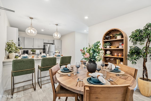 dining space featuring recessed lighting and light wood-style flooring