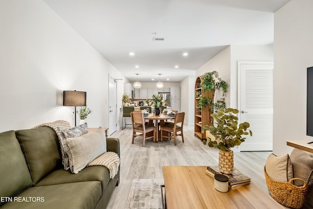 living area featuring visible vents, recessed lighting, and light wood-style floors