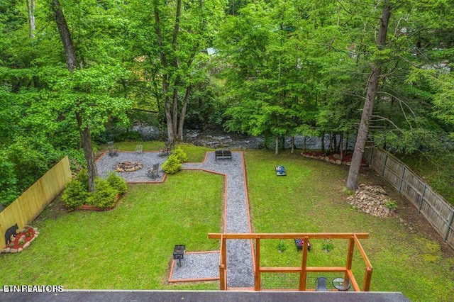 view of yard with a fire pit and a fenced backyard