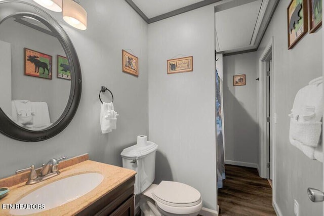 full bath featuring crown molding, toilet, vanity, wood finished floors, and baseboards