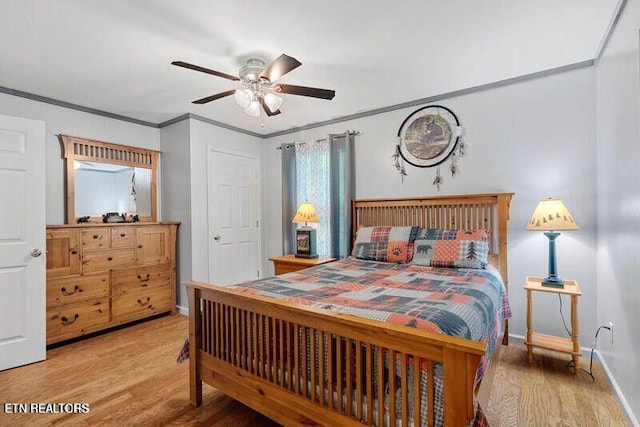 bedroom with a ceiling fan, crown molding, baseboards, and wood finished floors