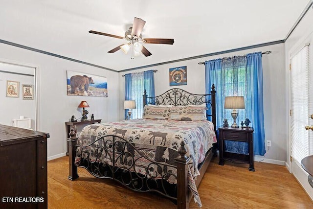 bedroom featuring light wood-style flooring, multiple windows, ornamental molding, and baseboards