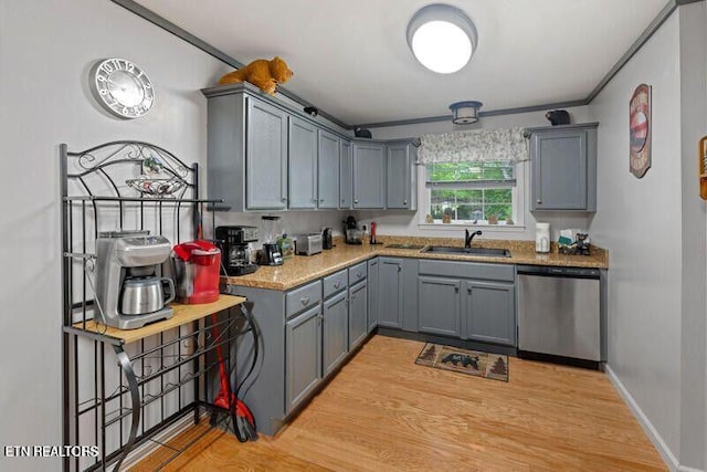 kitchen with baseboards, dishwasher, light countertops, gray cabinetry, and a sink