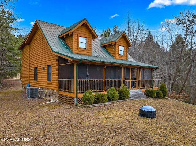 view of front of property featuring metal roof, central AC, and a sunroom