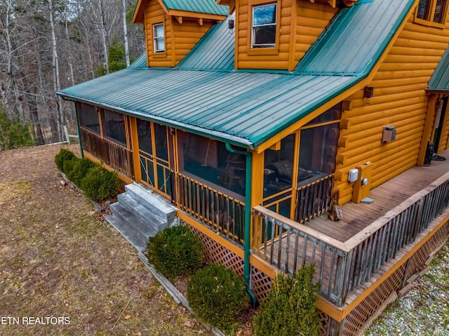 back of property with a sunroom and metal roof