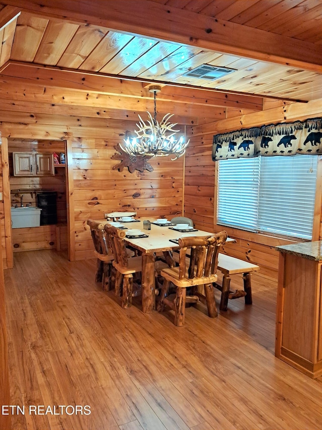 dining room featuring a notable chandelier, wood ceiling, and light wood-style floors