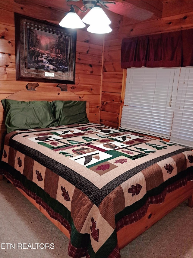 bedroom featuring wood walls and carpet