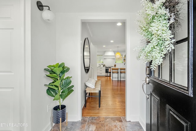 entryway with recessed lighting, stone finish flooring, and baseboards