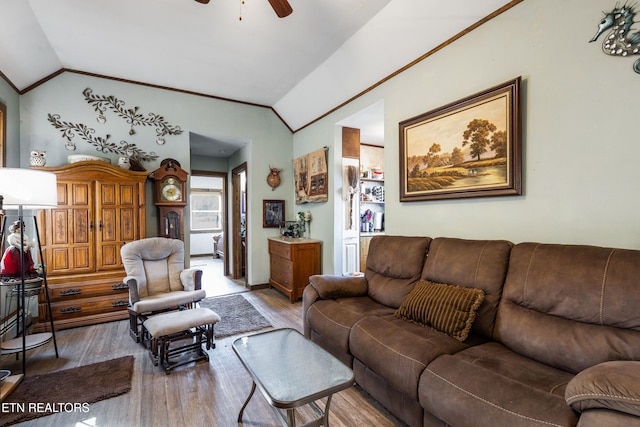 living area with vaulted ceiling, wood finished floors, and a ceiling fan