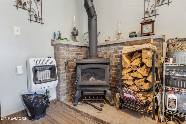 room details with a wood stove, heating unit, and wood finished floors