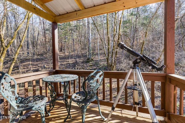 wooden terrace featuring a view of trees