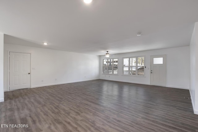 unfurnished living room featuring ceiling fan, baseboards, and dark wood-style flooring