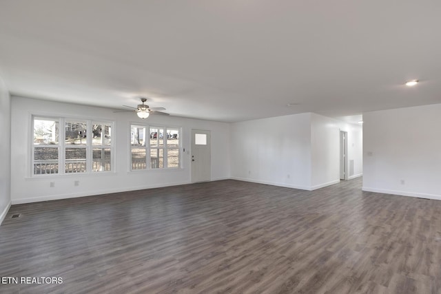 unfurnished living room featuring dark wood finished floors, a ceiling fan, and baseboards