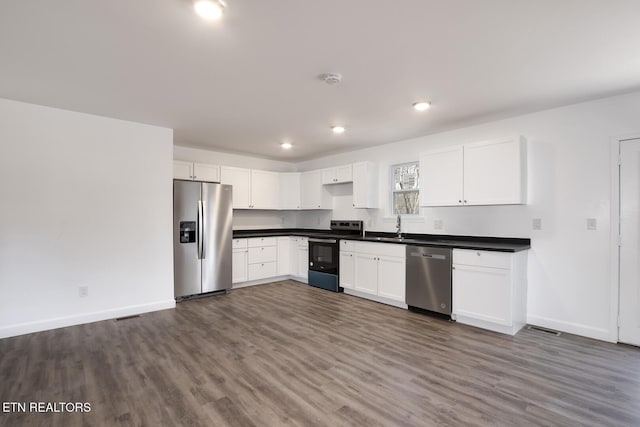 kitchen with stainless steel appliances, dark wood-type flooring, dark countertops, and baseboards