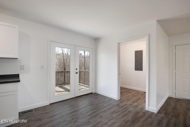 unfurnished dining area with french doors, visible vents, dark wood-type flooring, electric panel, and baseboards