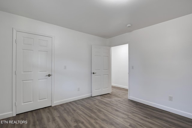 unfurnished bedroom with baseboards and wood finished floors