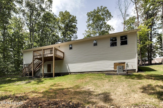 rear view of house featuring central AC unit, stairway, a deck, and a yard