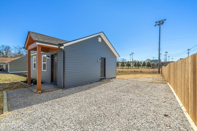 view of outbuilding with fence and driveway