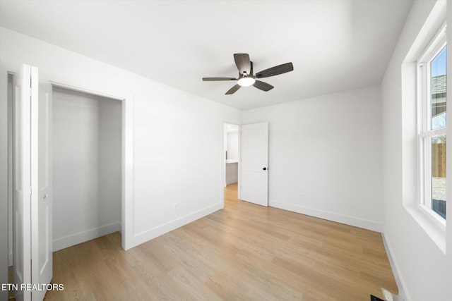 unfurnished bedroom with ceiling fan, light wood-type flooring, and baseboards