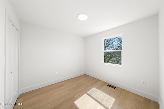 unfurnished bedroom with visible vents, a closet, light wood-style flooring, and baseboards